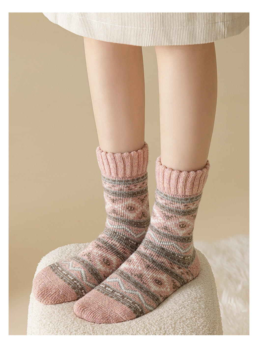 Pink geometric-pattern crew socks worn on a textured stool