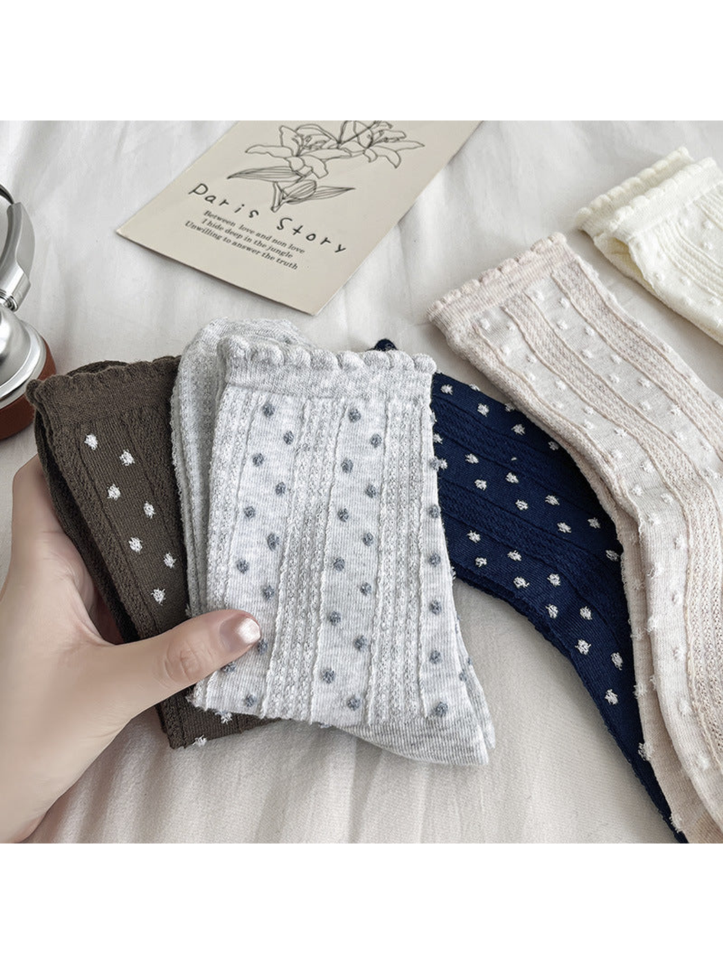 Five dotted crew sock colors arranged together and held by hand