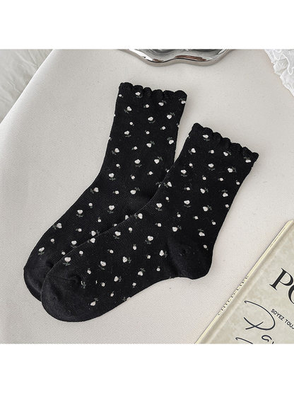 Black crew socks with small floral sprigs and scalloped cuffs