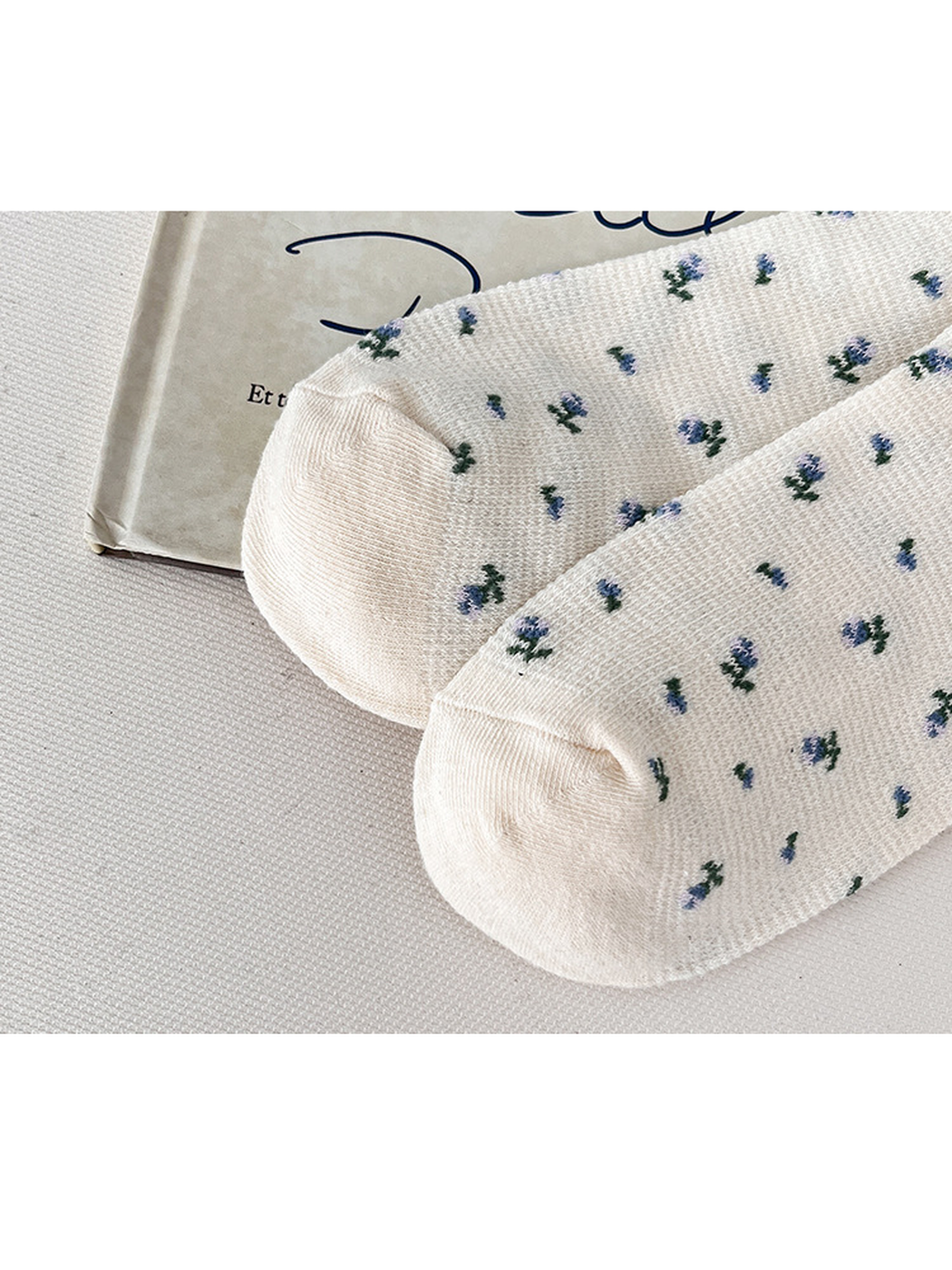 Close-up of the cream floral socks and curved toe seams