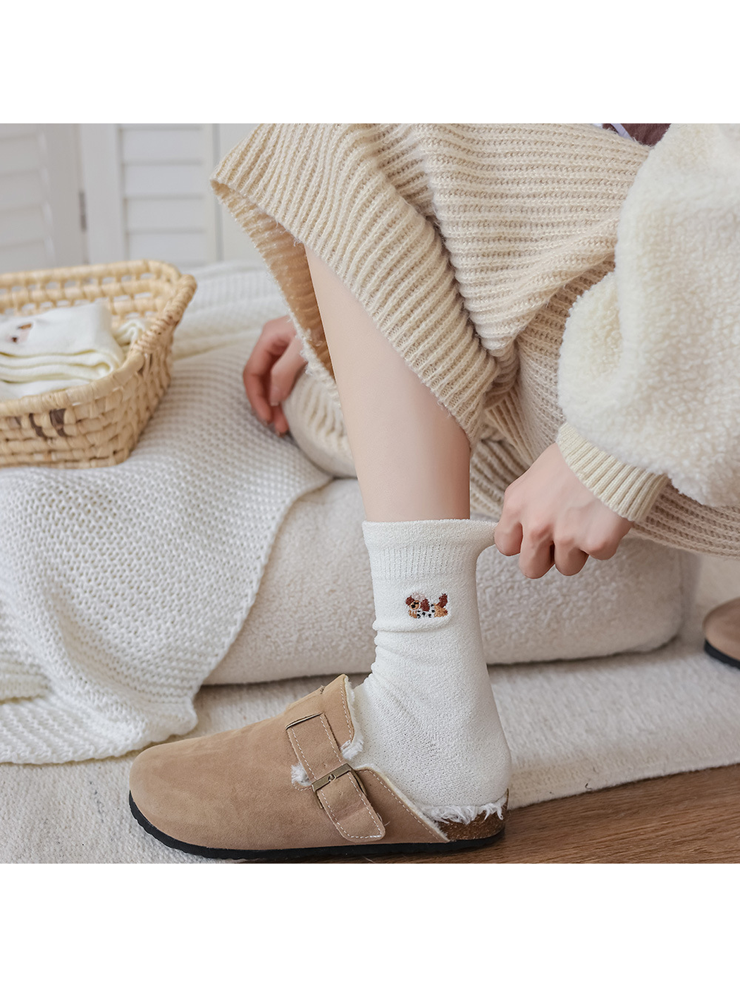 Ivory embroidered crew sock with folded cuff above a tan clog
