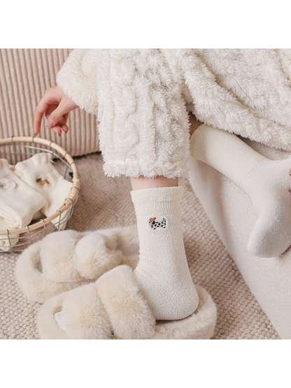 Ivory spotted dog crew socks styled beside fuzzy slippers