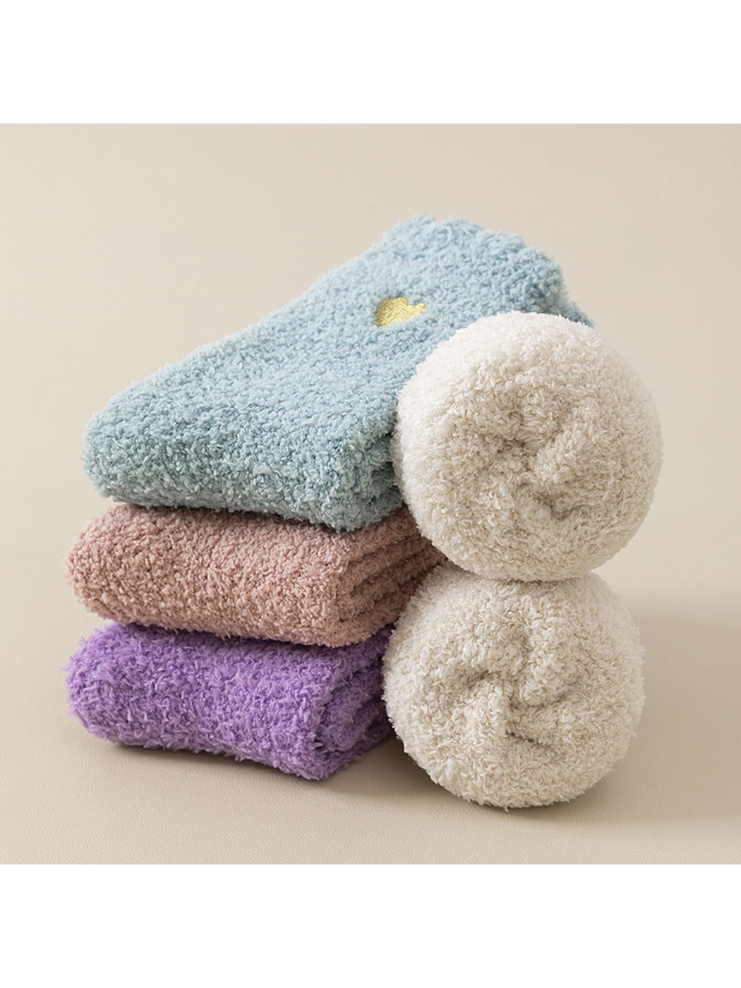 Rolled and folded fuzzy socks displaying the plush interior and several colors