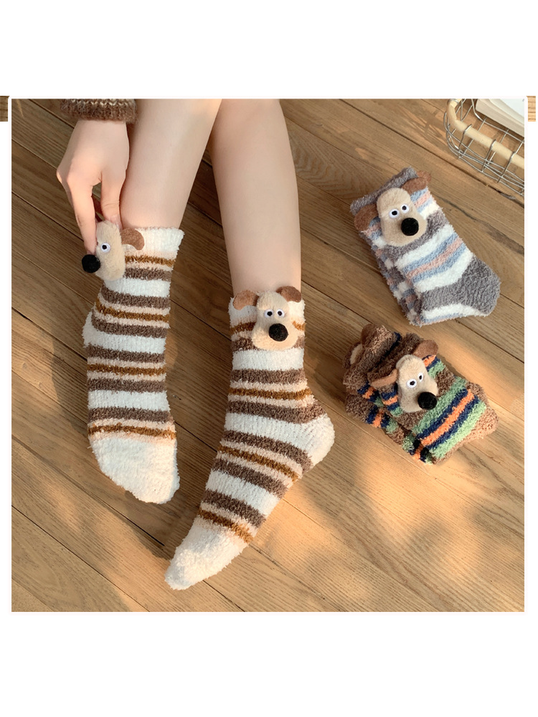 Ivory and brown striped dog socks worn on a wooden floor beside folded styles