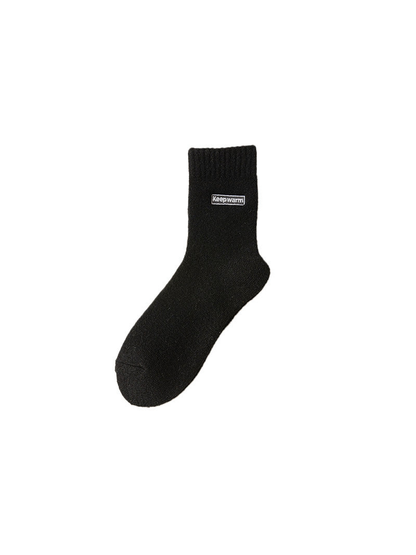 Black crew sock with ribbed cuff and label patch