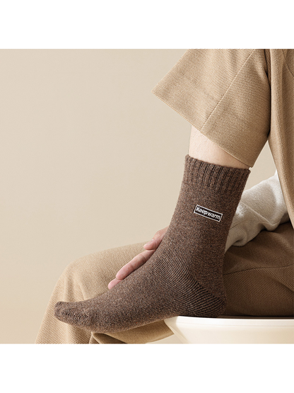 Brown crew sock with ribbed cuff in a seated view