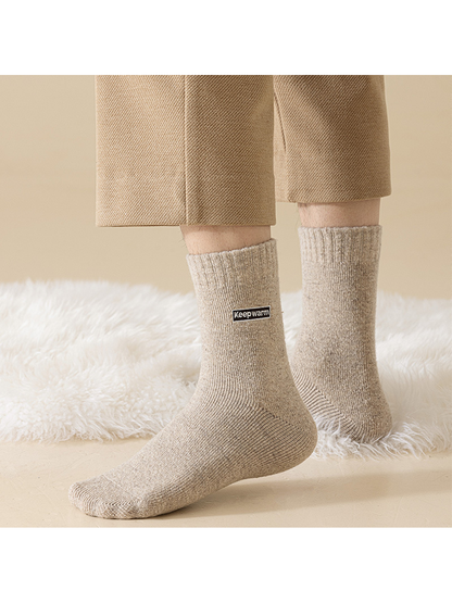 Beige crew socks worn against a light textured backdrop