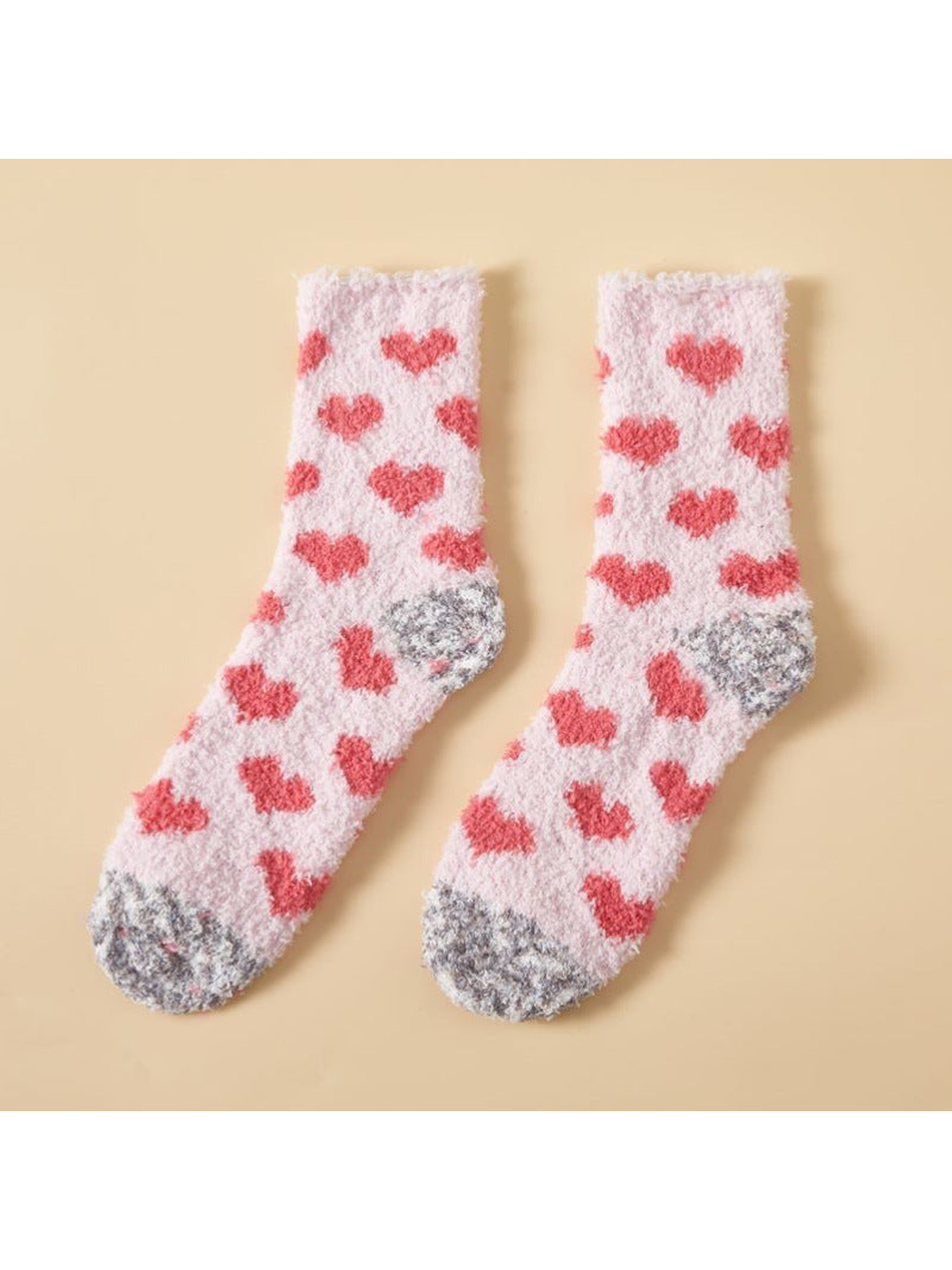 Light pink fuzzy crew socks with red hearts and mottled gray toes and heels