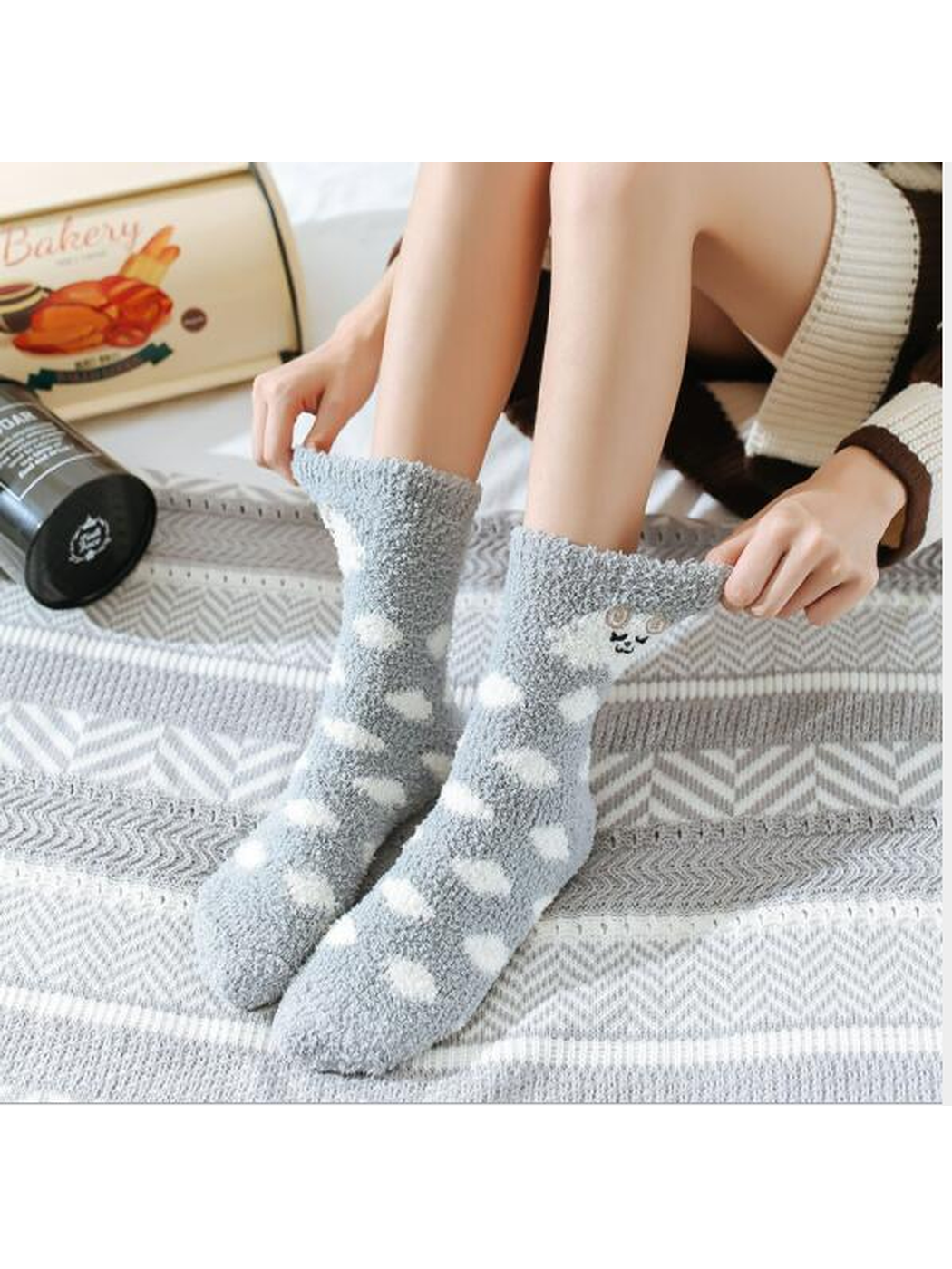 Gray fuzzy polka-dot crew socks worn above the ankle