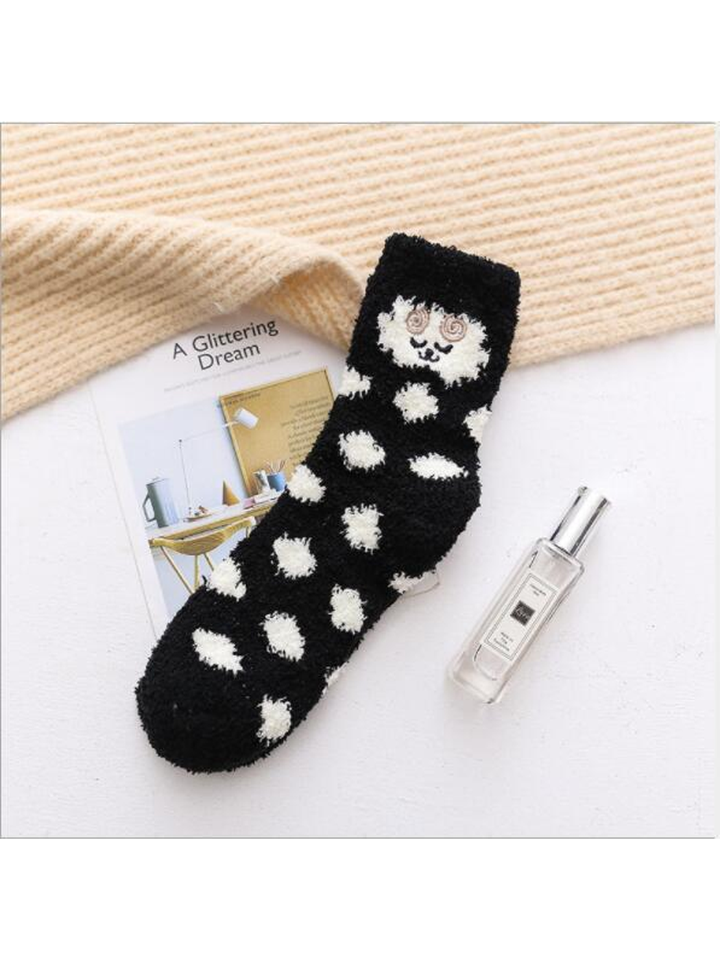 Black fuzzy crew sock with cream polka dots and embroidered face motif