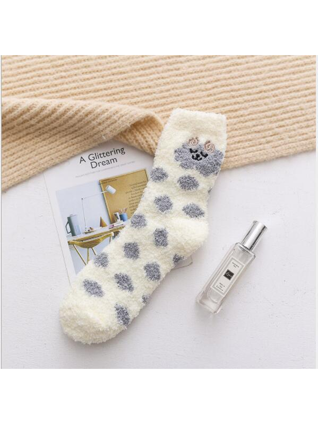 Ivory fuzzy crew sock with gray polka dots and embroidered face motif