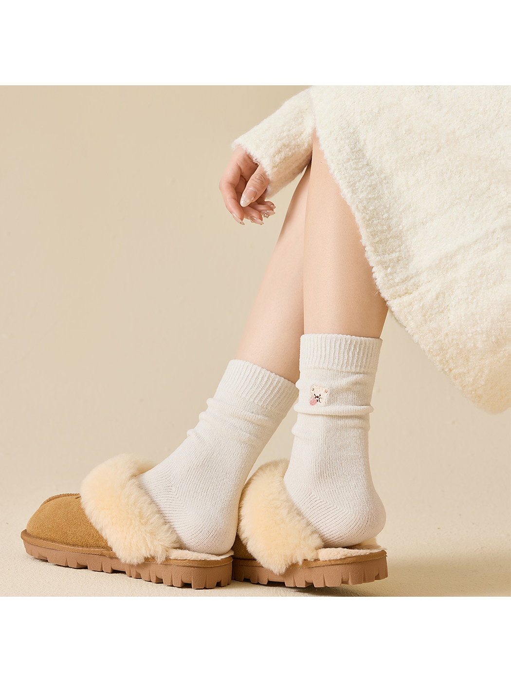 Light-colored embroidered crew socks worn scrunched at the ankles