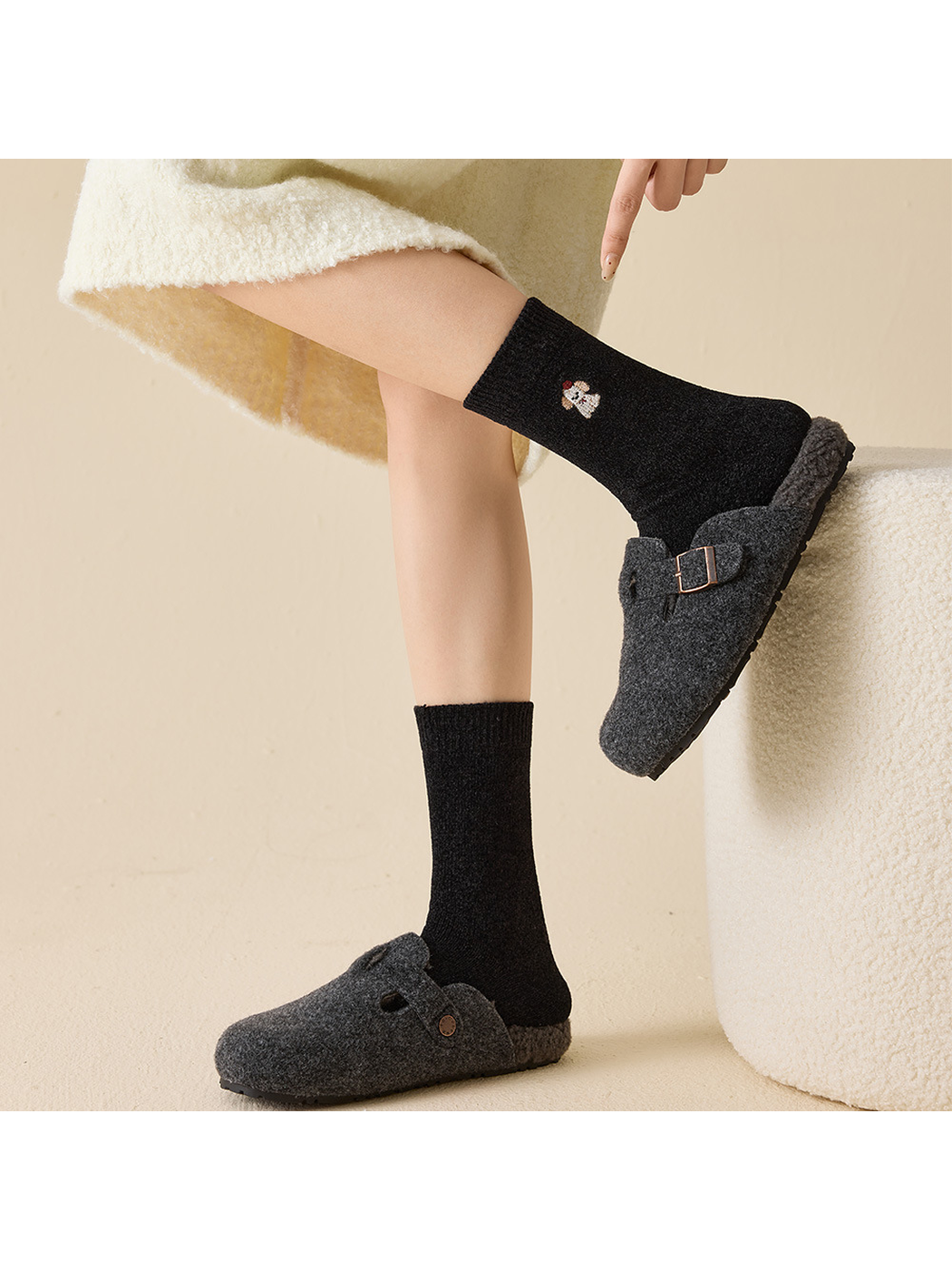Black embroidered crew socks styled with dark plush slippers