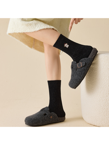 Black embroidered crew socks styled with dark plush slippers