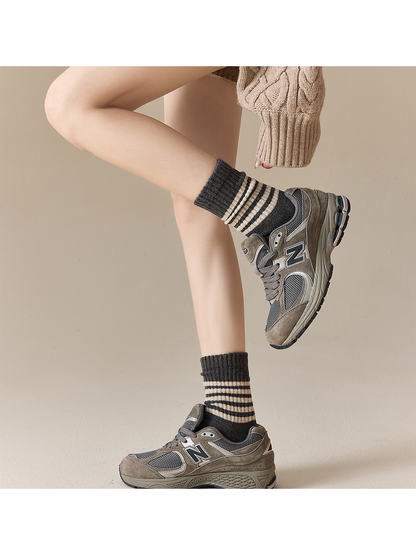 Dark gray striped crew socks styled with gray sneakers