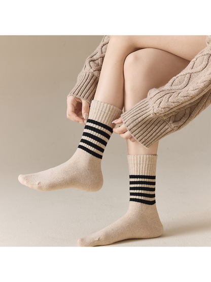 Beige striped crew socks worn in a seated view