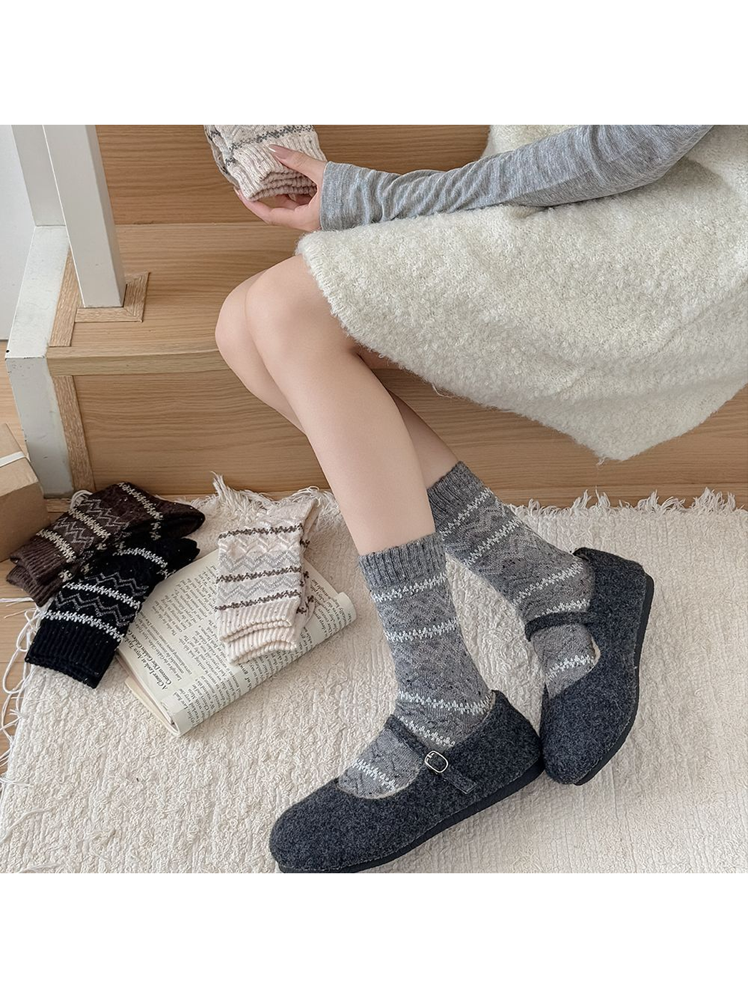 Gray geometric crew socks styled with charcoal flats in a seated view