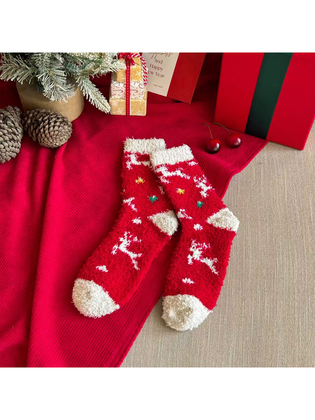 Red fuzzy crew socks with white reindeer motifs and ivory cuffs and toes