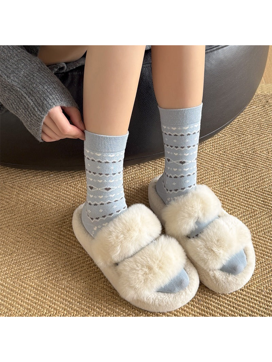 Light blue heart and geometric patterned crew socks worn with plush slippers