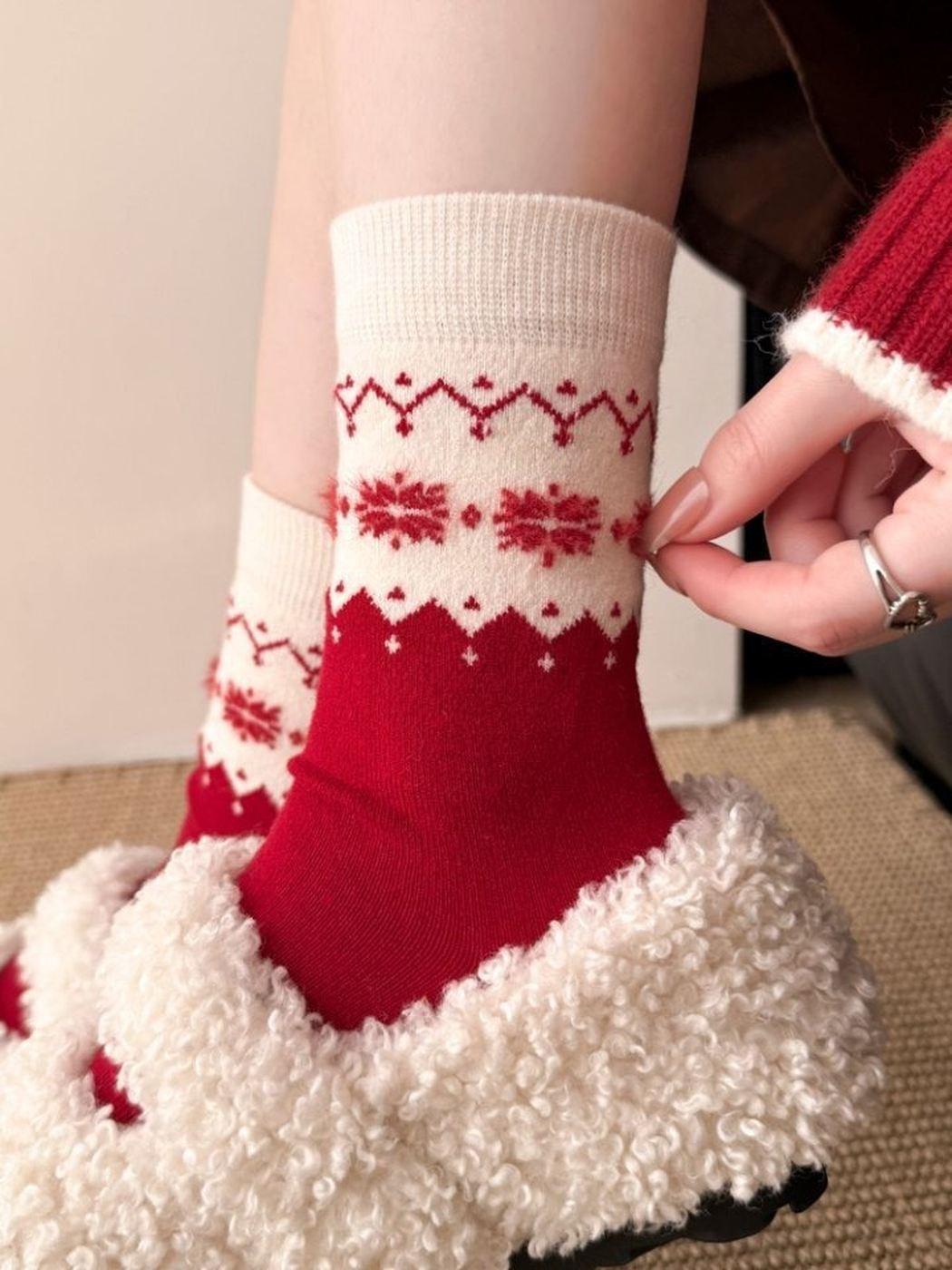 Red crew socks with ivory snowflake and geometric cuff patterns