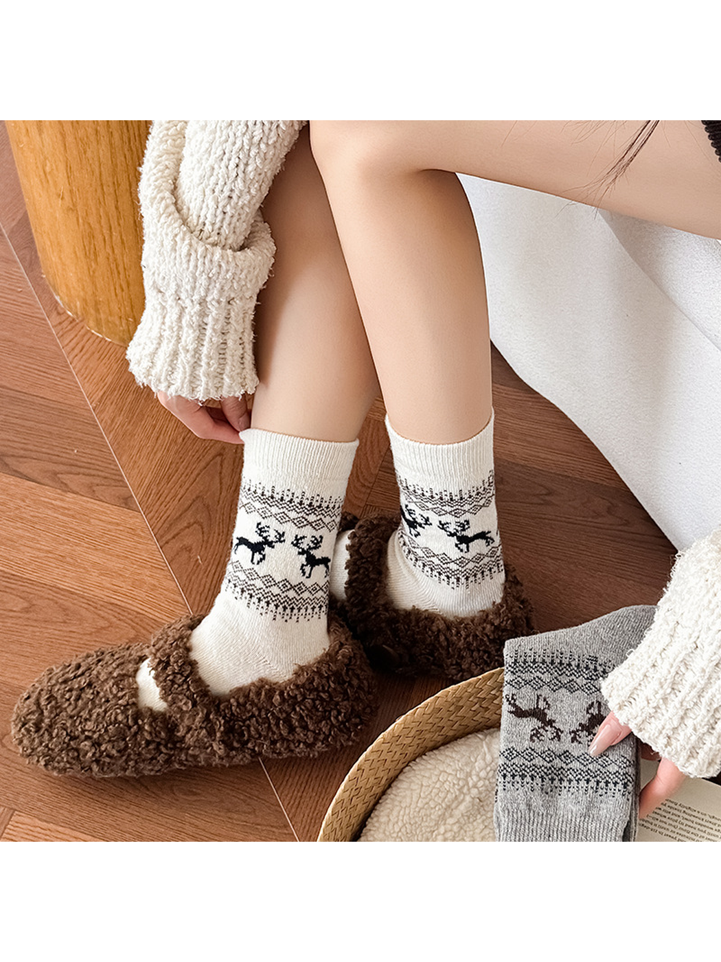 Ivory deer-pattern crew socks styled with brown slippers, close view