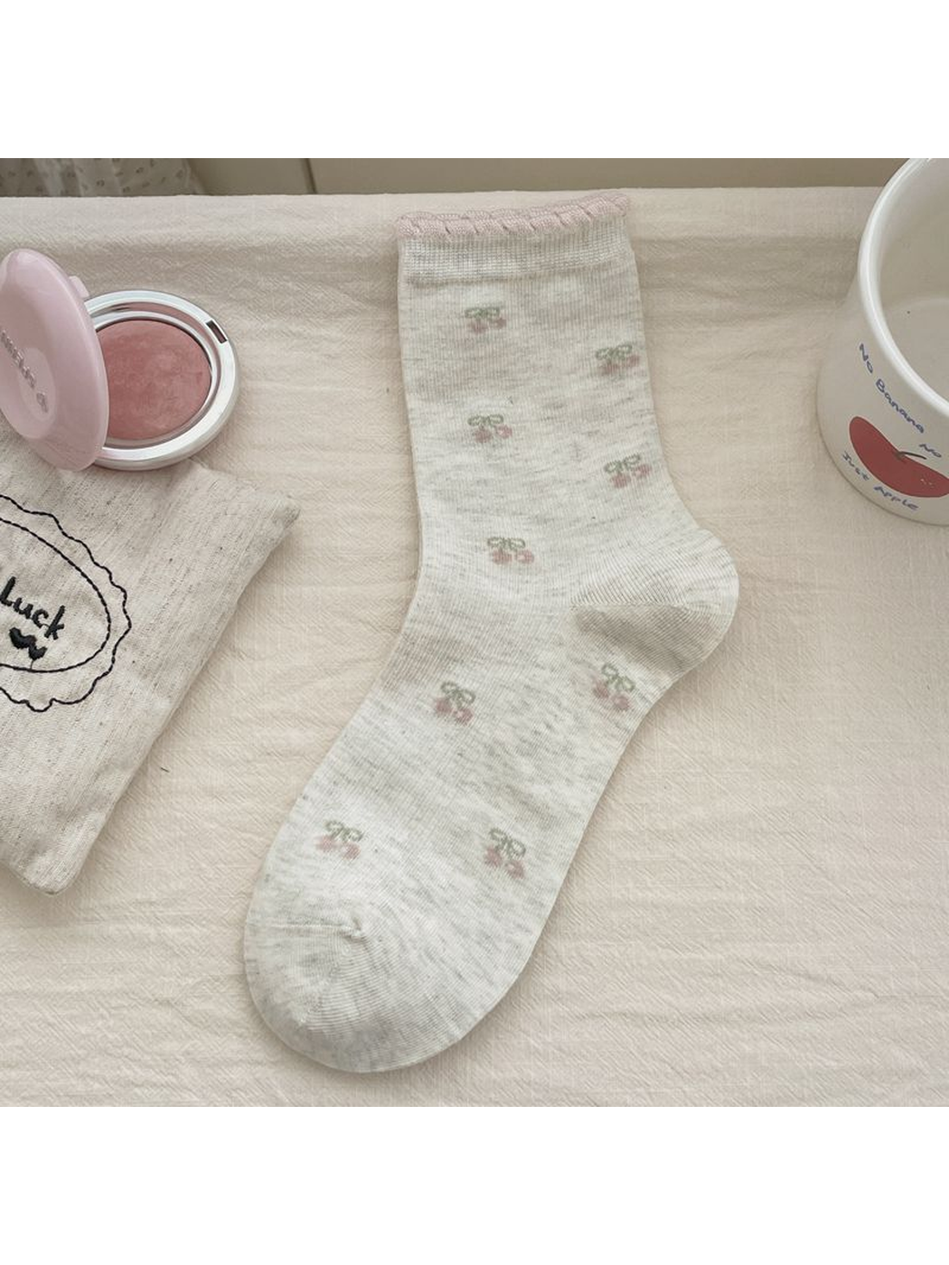 Gray crew sock with small cherry motifs and a pink-trimmed cuff