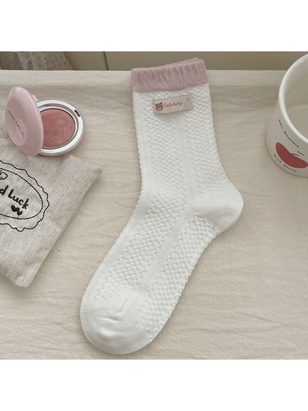 White textured crew sock with a pink cuff and woven label accent