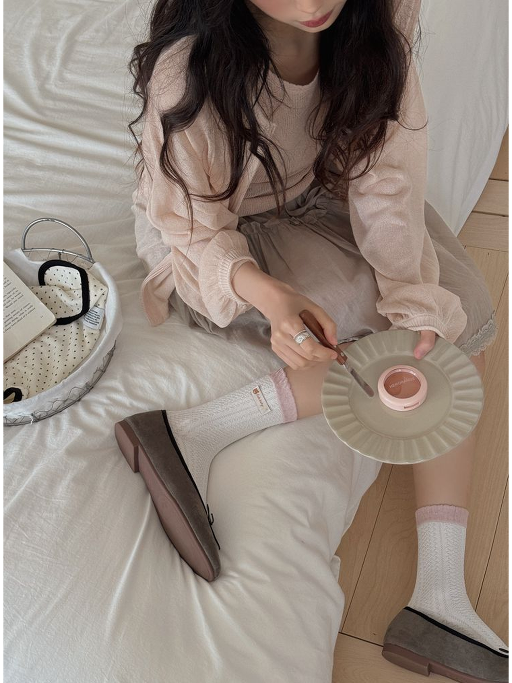 White textured crew socks with pink cuffs and woven label accents worn with gray flats