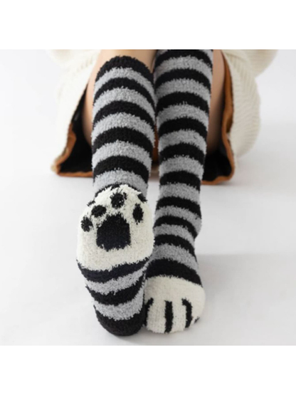 Black and gray striped fuzzy knee-high socks showing the cat-paw sole design
