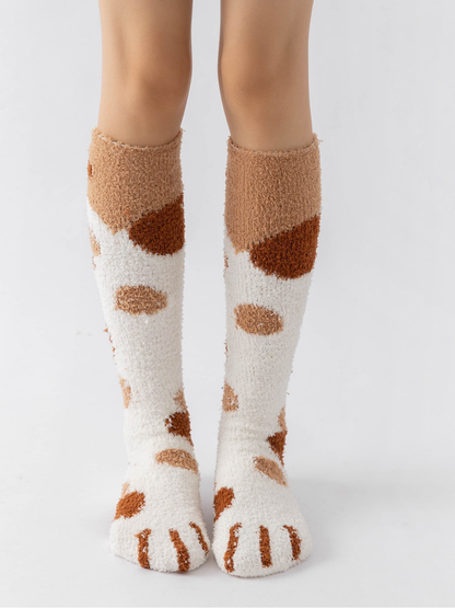 Cream fuzzy knee-high socks with tan and brown spots and cat-paw toes, front view
