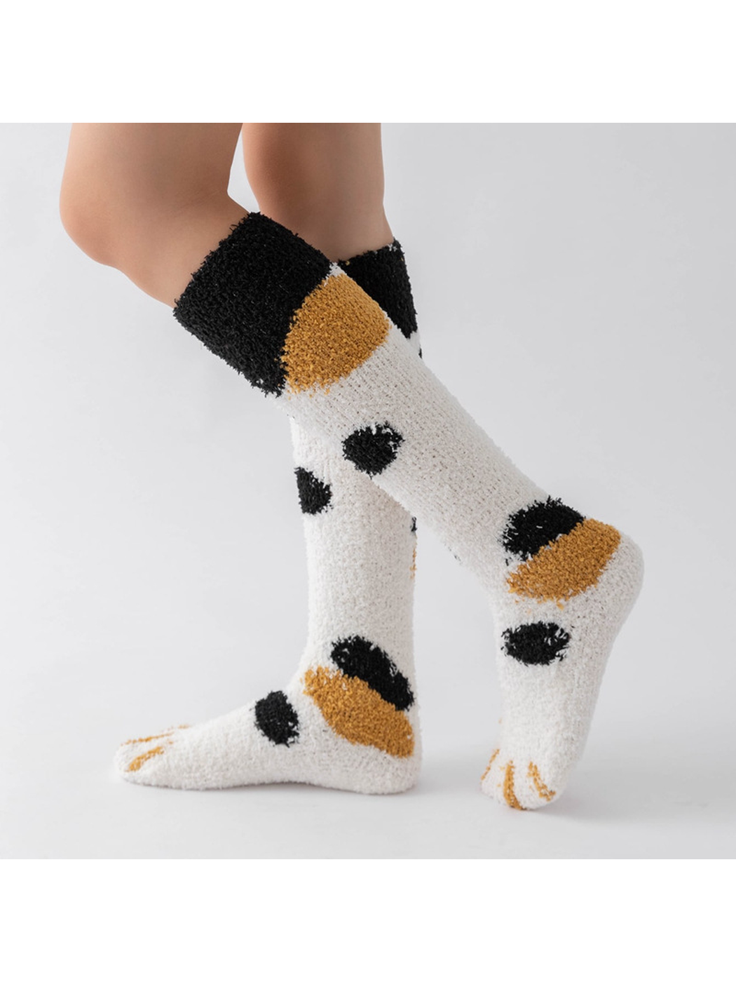 Cream fuzzy knee-high socks with black and mustard spots, side view