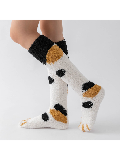 Cream fuzzy knee-high socks with black and mustard spots, side view