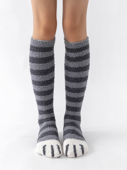 Light gray and dark gray striped fuzzy knee-high socks with white cat-paw toes, front view