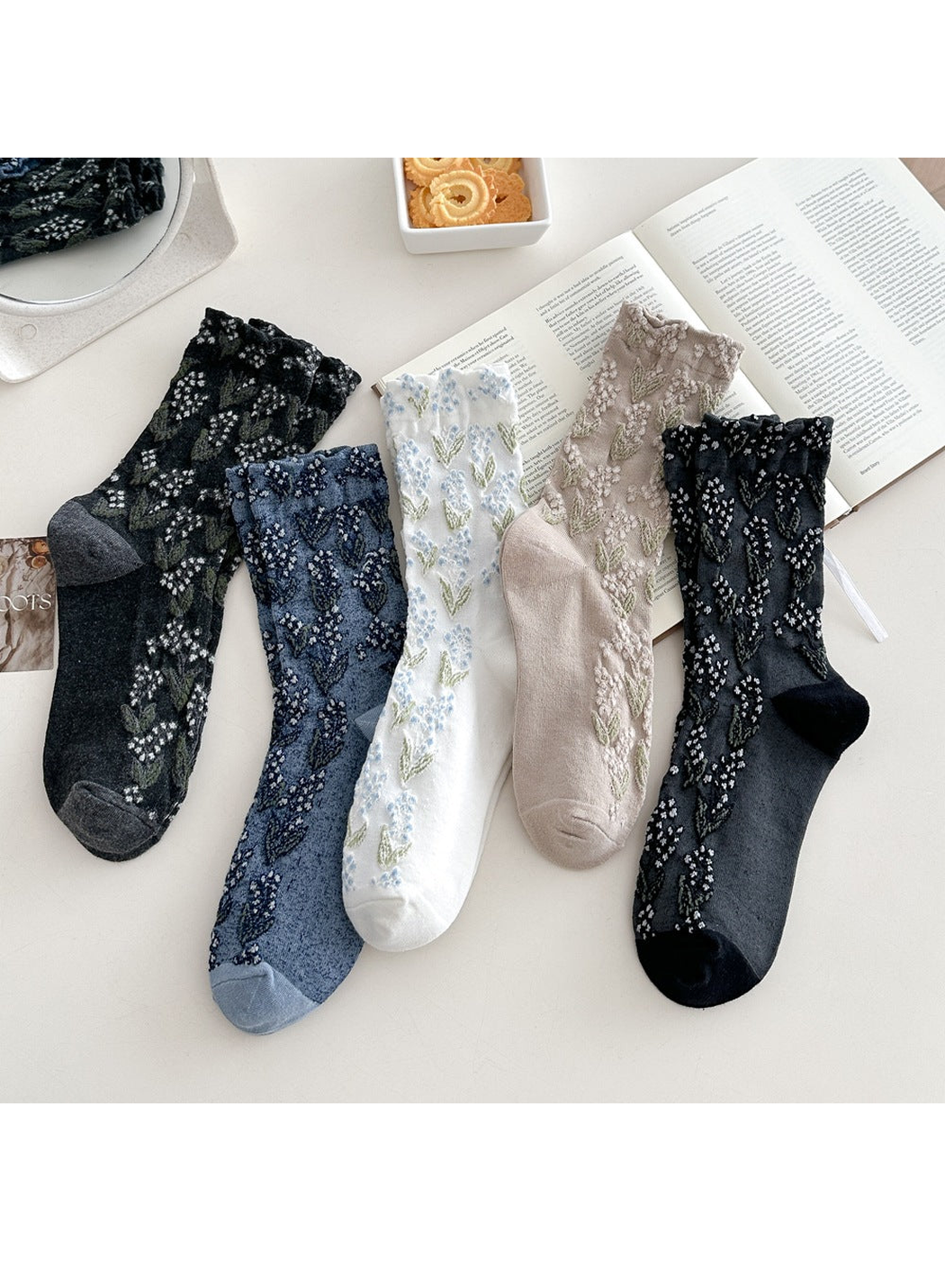 Five floral crew sock color variants arranged together on a tabletop