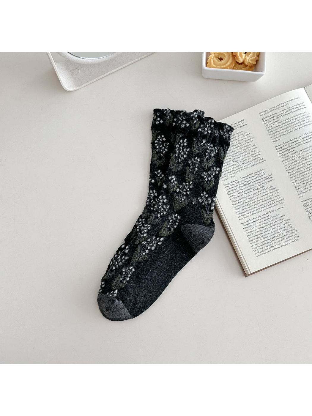 Dark gray crew sock with raised floral motifs and a ruffled cuff