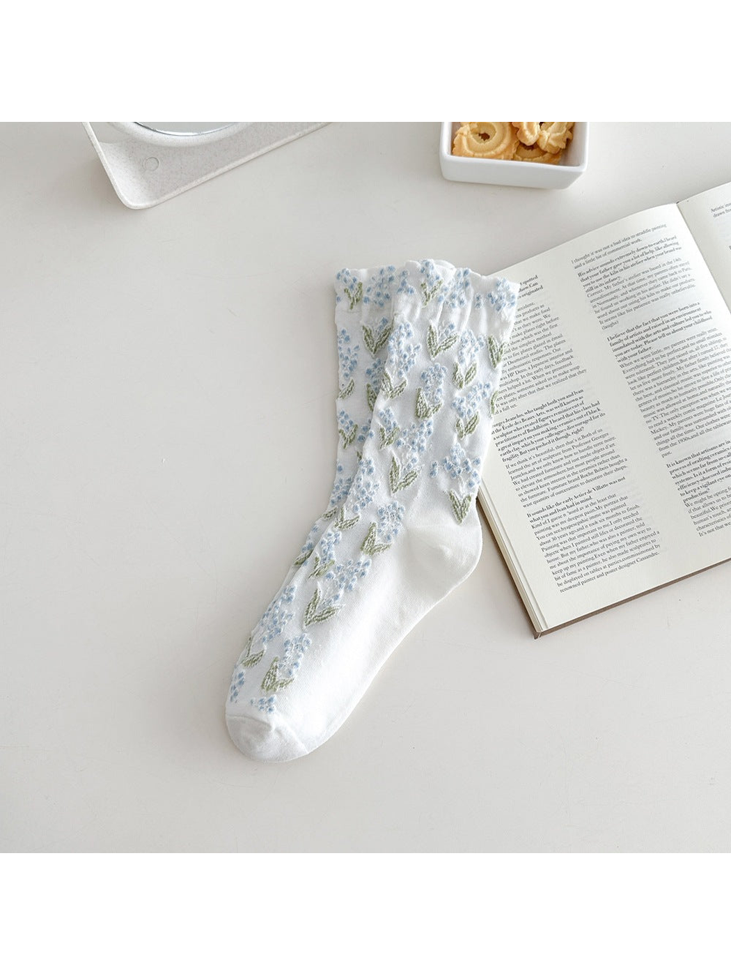 White crew sock with blue floral motifs and a ruffled cuff
