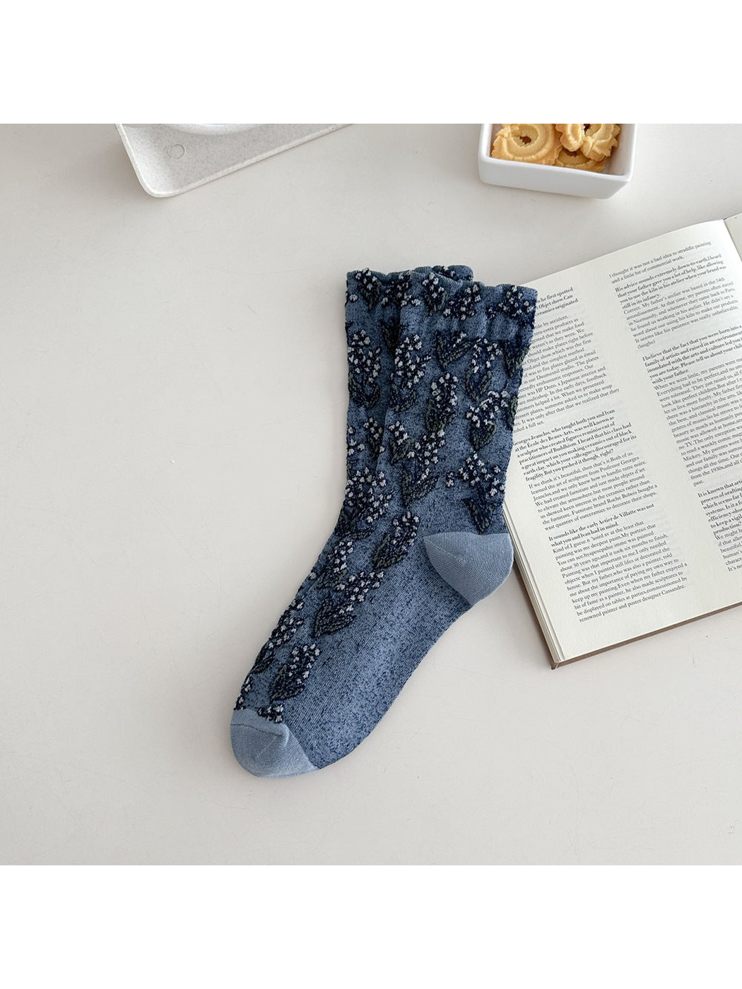 Blue crew sock with dark floral motifs and a ruffled cuff
