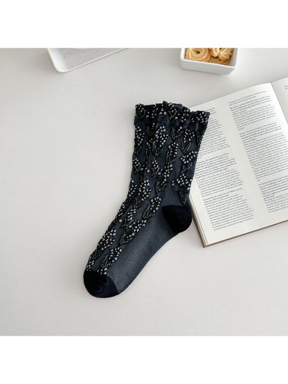 Black crew sock with floral motifs and a ruffled cuff