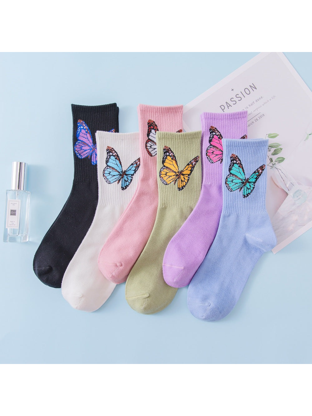 Six colors of crew socks with large butterfly motifs displayed together