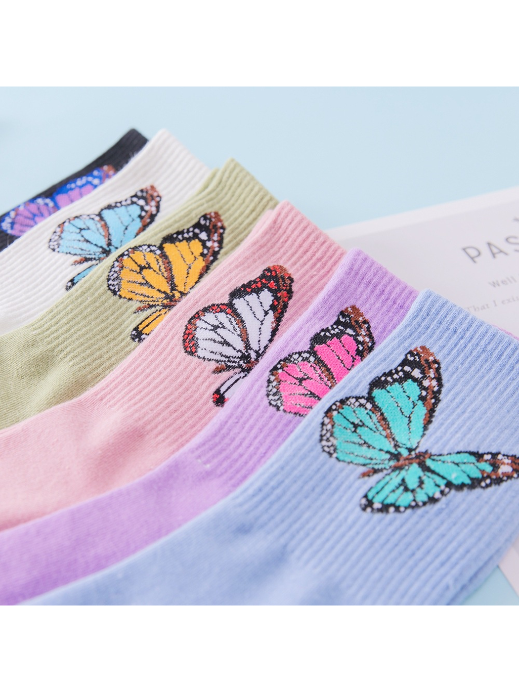 Close-up of butterfly motifs and vertical ribbing across six sock colors