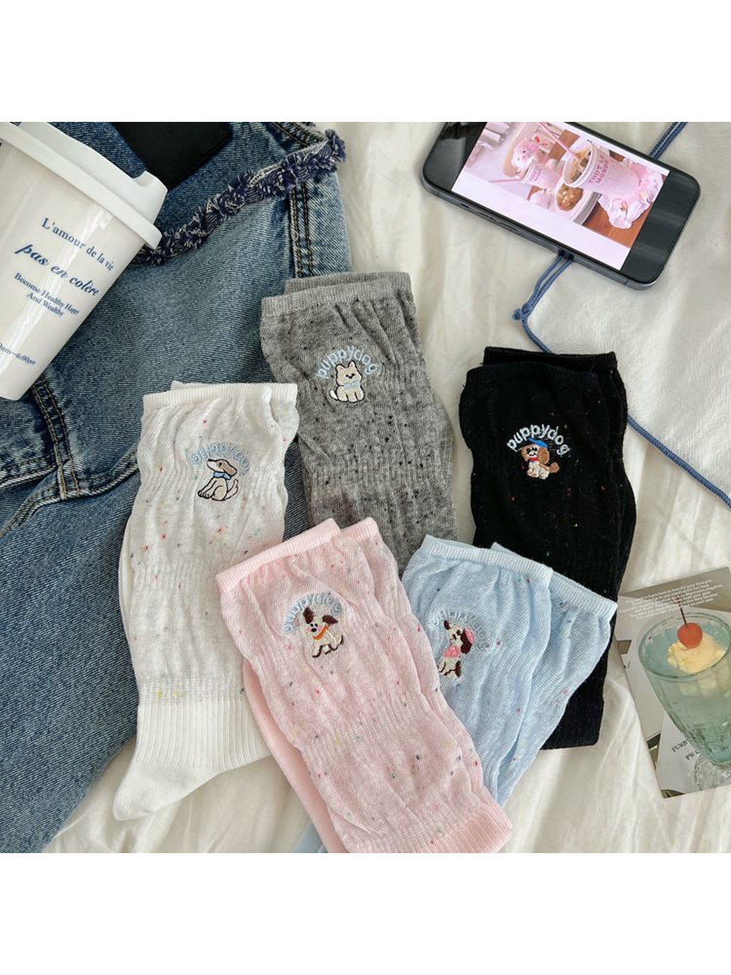 White, pink, black, gray and light blue embroidered crew socks displayed together