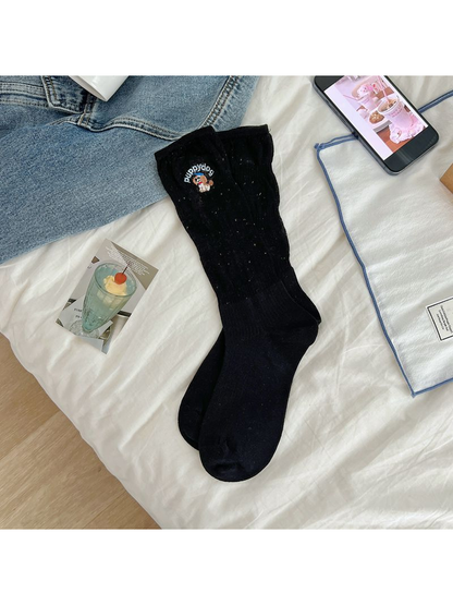 Black crew socks with subtle flecks and an embroidered dog motif