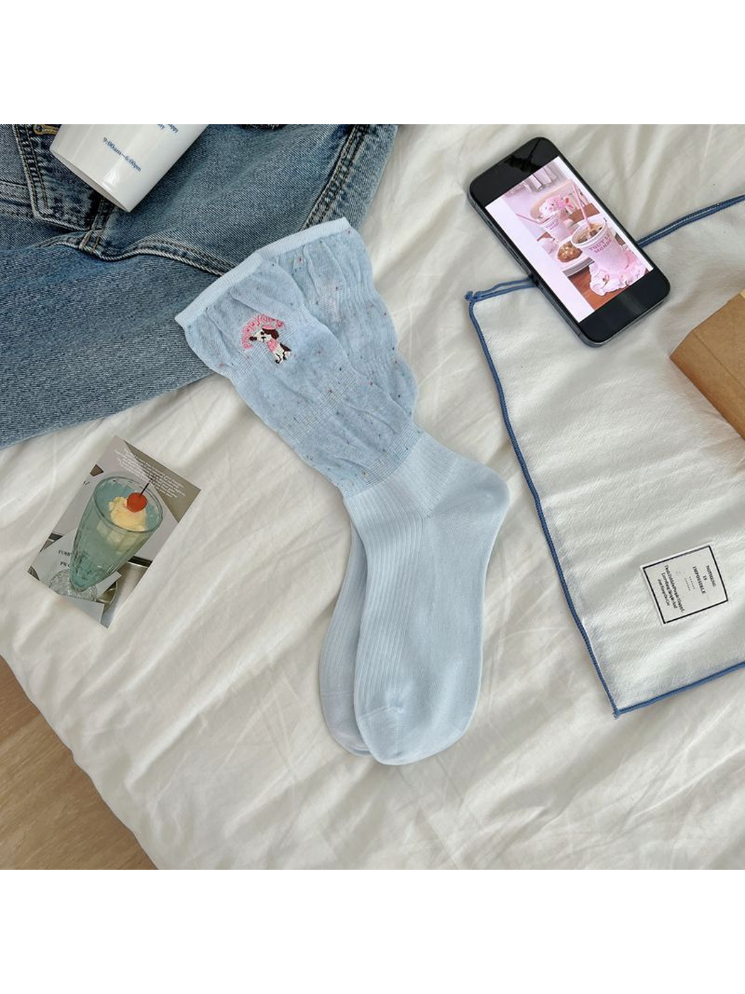 Light blue crew socks with a flecked upper section and embroidered dog motif