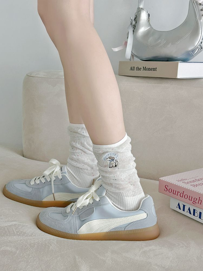 White embroidered crew socks worn with light blue sneakers