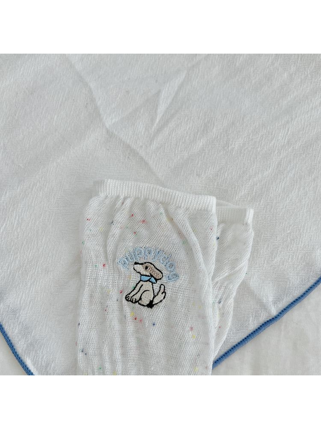 Close-up of the embroidered dog motif and multicolored flecks on a white sock