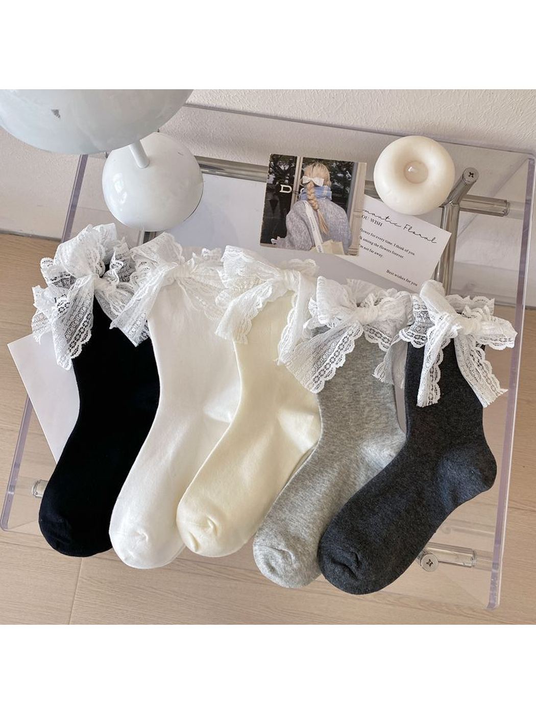 Black, white, ivory, dark gray and light gray lace-bow crew socks displayed together