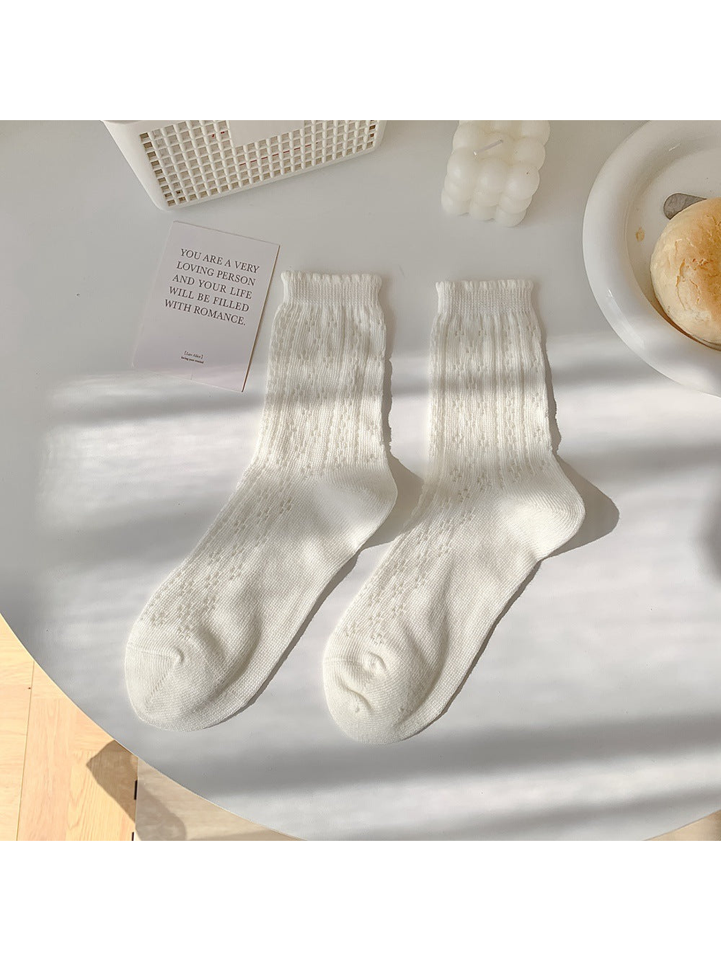 White pointelle crew socks laid flat in a pair