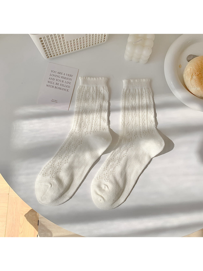 White pointelle crew socks laid flat in a pair