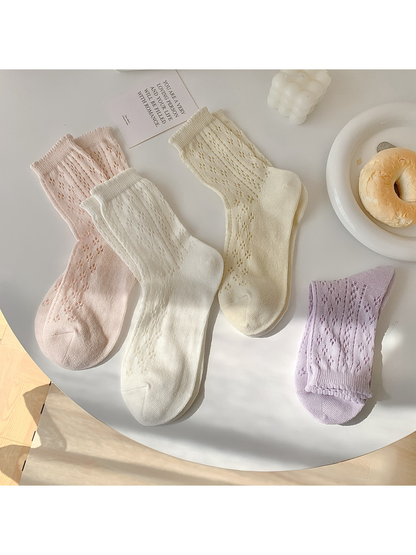 Pink, white, cream and lavender pointelle crew socks displayed together