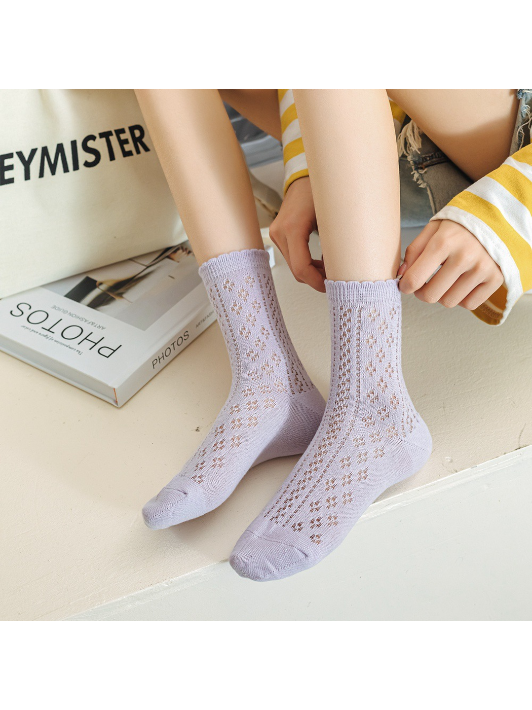 Lavender pointelle crew socks worn while seated indoors